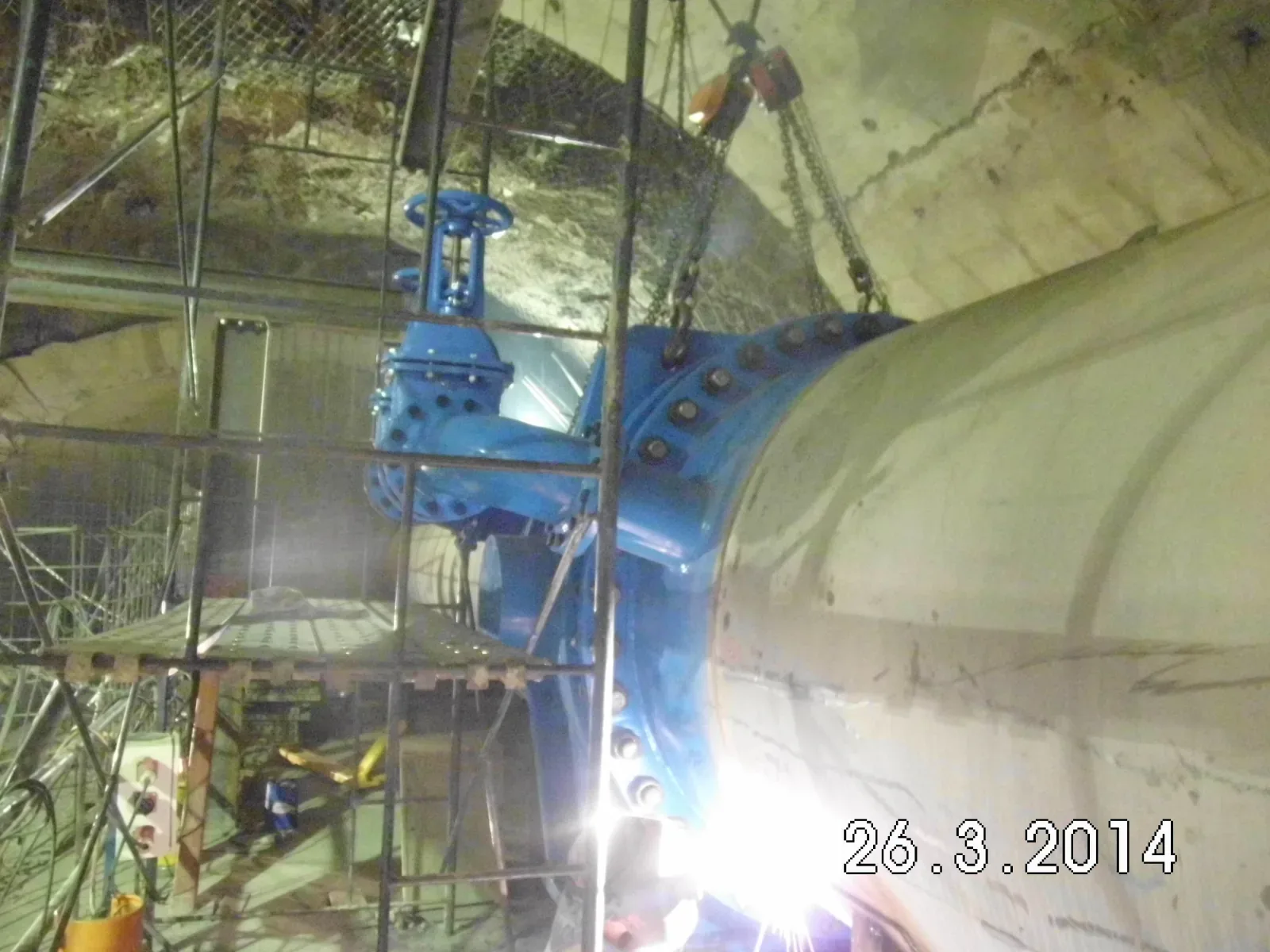 Válvula azul ya instalada en línea con la tubería del túnel, con el destello de una soldadura en la base